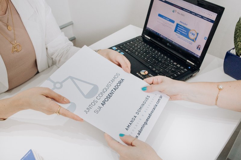 Dra. Amanda Domingues entregando documentação de aposentadoria ao cliente